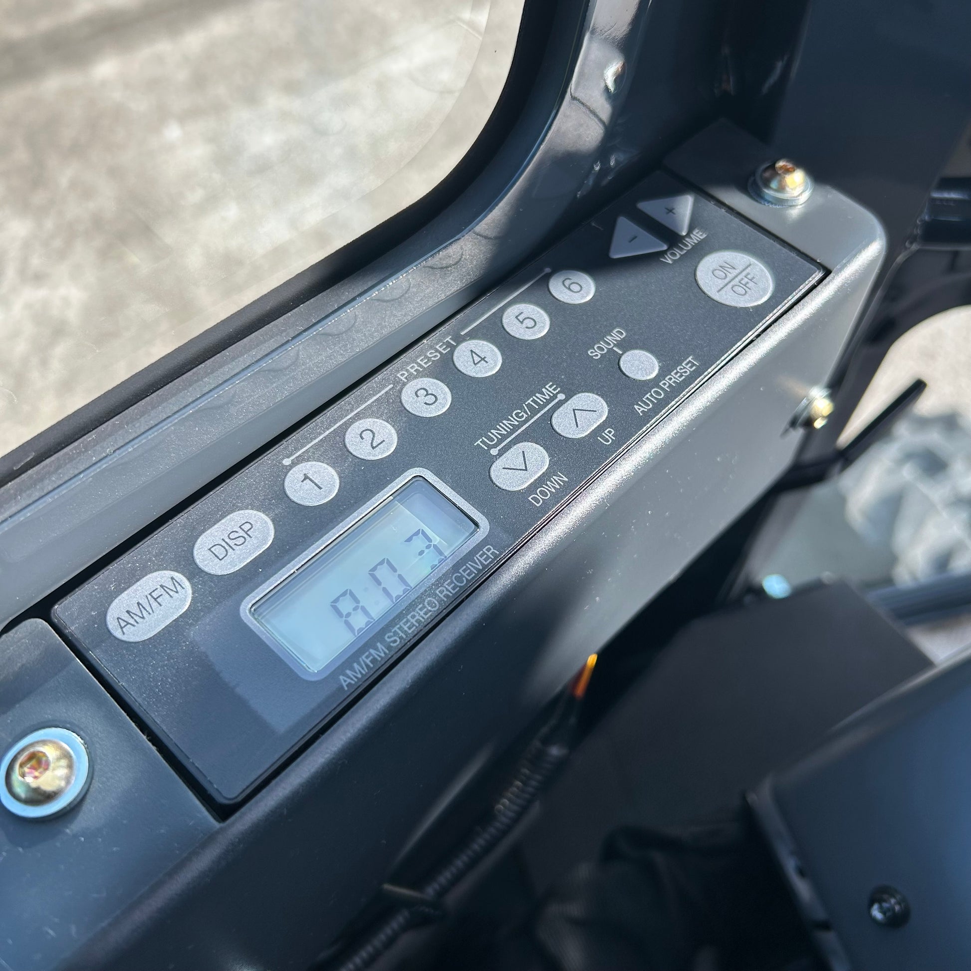 Close-up of a vehicle's control panel with a digital display and buttons.